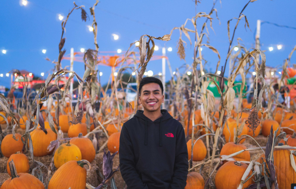 Joaquin Flores stands in a pumpkin patch